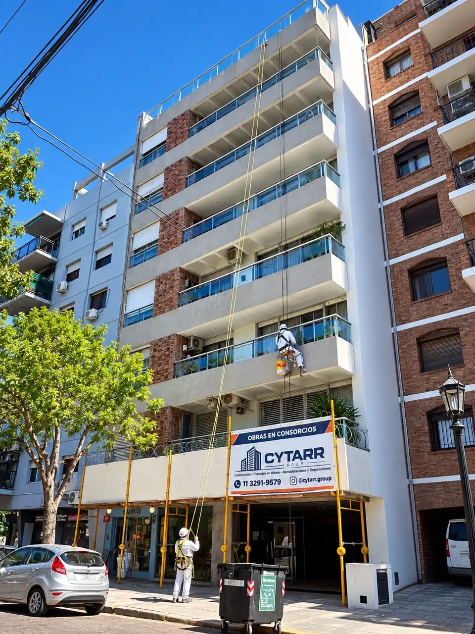 Obra de CYTARR GROUP en un consorcio: silletero trabajando en la fachada y cartel de obra